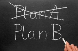 Crossing out Plan A and writing Plan B on a blackboard.